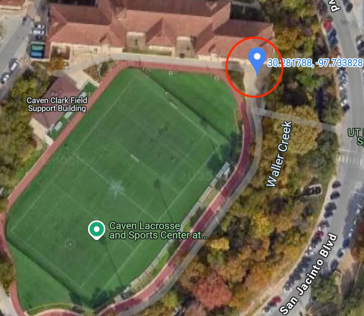 This image shows an ariel view of Caven Clark Field. There is a blue pin inside a red circle indicating the meeting place.